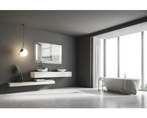 Badkamer met bad, wastafel, spiegel en groot raam voor een lichte sfeer