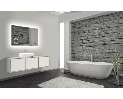 Badkamer met verlichte spiegel, wastafel, opzetwastafel en badkuip voor stenen muur