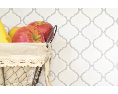 Decoratieve tegelwand met fruitmand op de voorgrond.