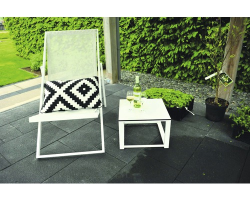 Terrasscène met tuinmeubelen: ligstoel, kussen, tafel, drankjes en planten