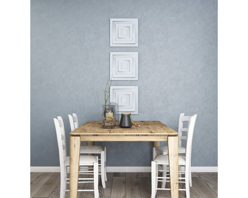 Eettafel met stoelen en decoratie in een lichte ruimte.