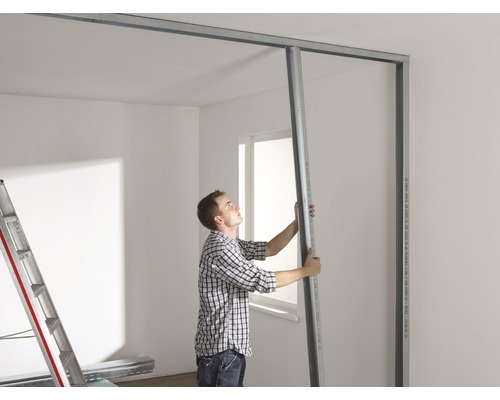 Man monteert een gipsplaatwand met metalen profielen in een kamer.