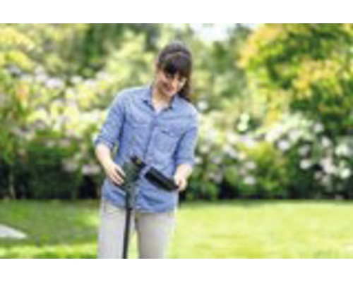 Een vrouw monteert een tuingereedschap buitenshuis.