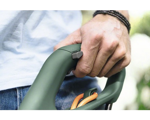 Close-up van een persoon die de handgreep van een grasschaar vasthoudt