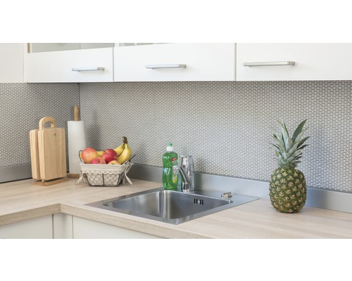 Keukenscène met spoelbak, kraan, snijplanken, keukenrol, fruitmand en ananas