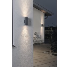 Twee grijze buitenwandlampen verlichten een muur van een huis.