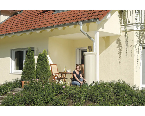 Huis met regenwatertank, terras en vrouw met gieter