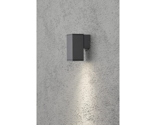 Grijze wandlamp aan een muur