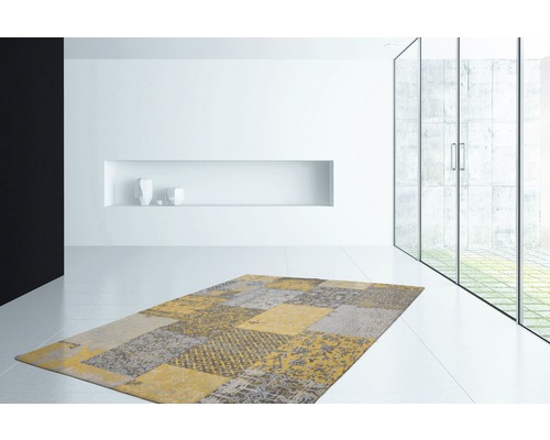 Modern tapijt met patchworkmotief in een lichte kamer.