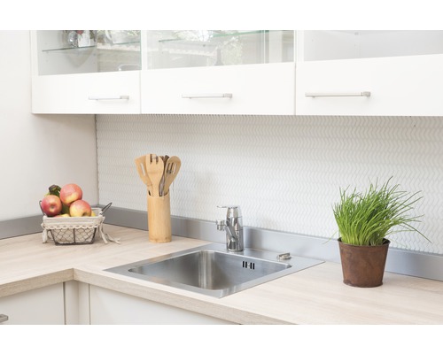 Spoelbak met kraan en keukengerei op een licht werkblad