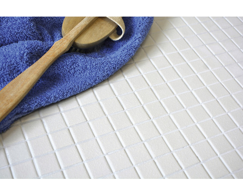 Witte mozaïektegels met borstel en handdoek