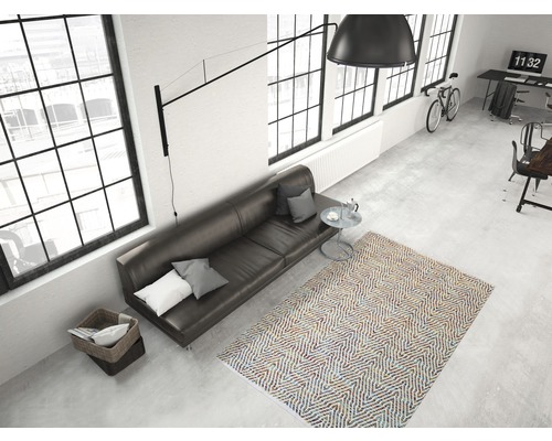 Weergave van een woonkamer met bank, vloerkleed en raampartij