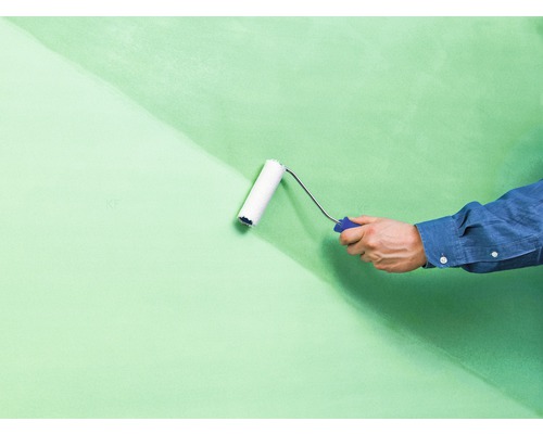 Een muur wordt geschilderd met een verfroller.