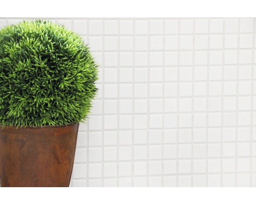 Decoratieve kunstplant in een pot voor een witte mozaïekachtergrond