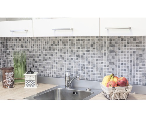 Keukenscène met mozaïektegels, spoelbak en decoratieve elementen.