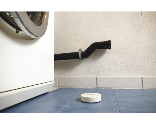 Wasmachine, afvoerpijp en doseerhulp voor wasmiddel op blauwe tegelvloer