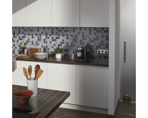 Keukenscène met mozaïektegels, werkblad, keukengerei en eettafel