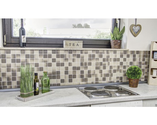 Keukenscène met mozaïektegels, kookplaat en decoratieve elementen.