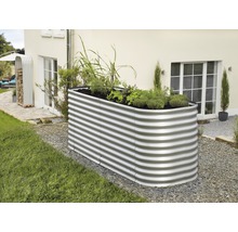 Metalen plantenbak met planten in de tuin