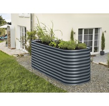 Metalen plantenbak met planten in de tuin