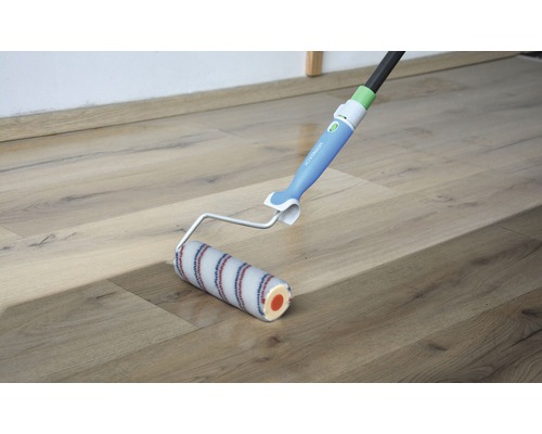 Verfroller met telescopische steel op een houten vloer