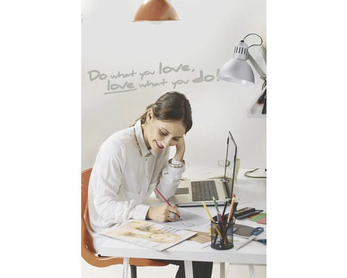 Vrouw werkt aan een bureau met een laptop en kantoorbenodigdheden.