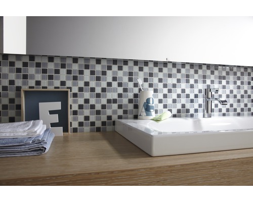 Badkamer met mozaïektegels, wastafel en kraan op een wastafelmeubel