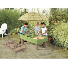 Drie kinderen spelen aan een groene zand- en watertafel met parasol in de tuin.