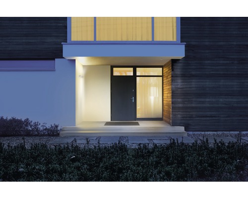 Verlichte ingang van het huis met voordeur en buitenmuurlampen