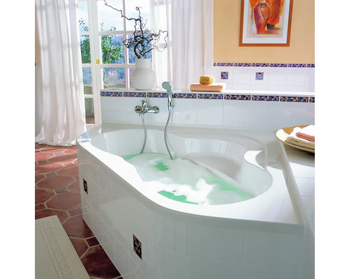 Badkamer met hoekbad, kraan, decoratie en raam