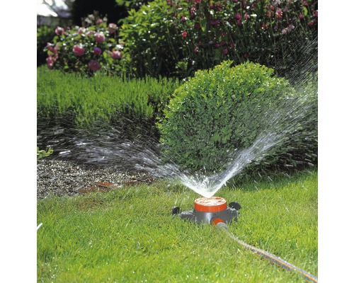 Tuinsproeier besproeit gazon in tuin