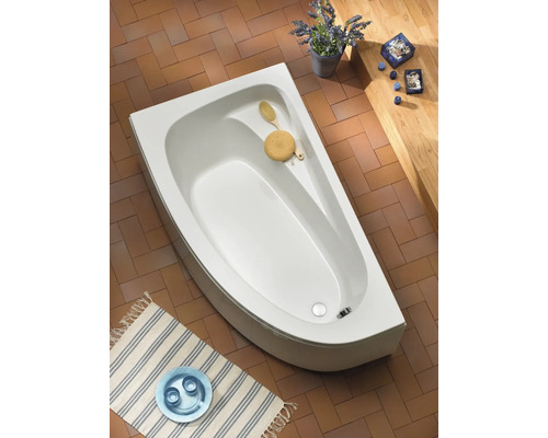 Afbeelding van een badkamerscène met een wit hoekbad, badkameraccessoires en vloertegels.