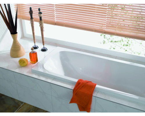 Badkamer met ligbad, jaloezieën, decoratie en handdoek