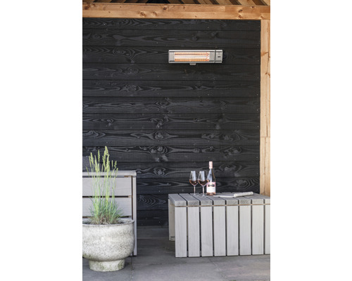 Terras met infraroodstraler, houten wand, tafel, wijnfles en glazen