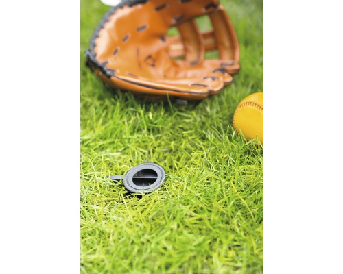 Baseballhandschoen, honkbal en zwart mangatdeksel op gras
