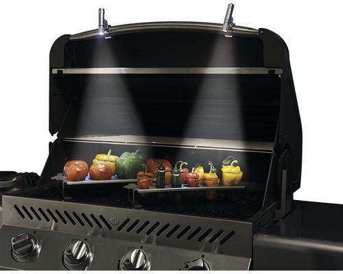 Gasbarbecue met open deksel, verlichte binnenkant en paprika''s op grillroosters