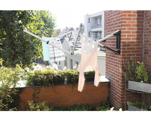 Wandgemonteerd wasrek op een balkon met opgehangen kleding.