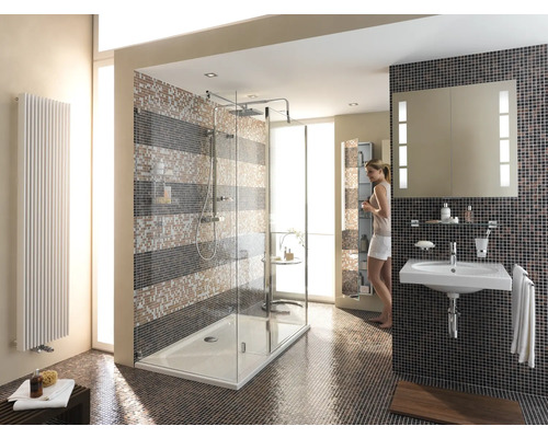 Lichte badkamer met douche, wastafel en radiator tegen mozaïektegels