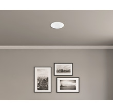 Plafond met ingebouwde ronde lamp en drie ingelijste foto''s aan de muur