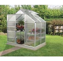 Kas met plantenrekken in de tuin