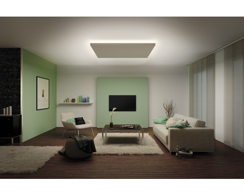 Woonkamer met plafondlamp, bank en fauteuil