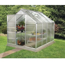 Kas met planken en planten in de tuin