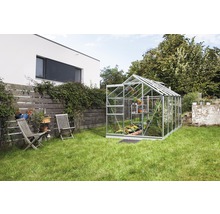 Kas in de tuin met planten en tuinmeubelen