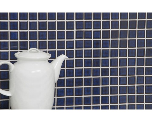 Mozaïektegelwand met witte voegen en een witte theepot