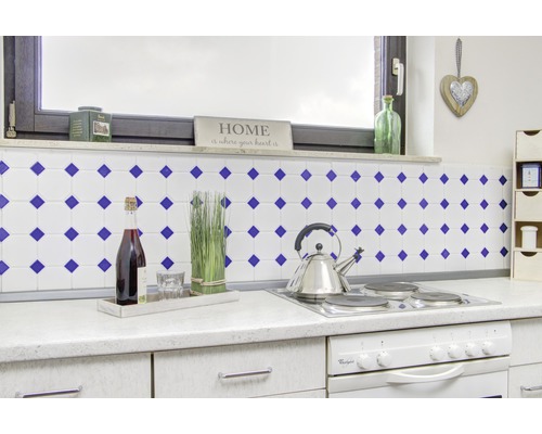 Keukenopstelling met tegels, kookplaat, oven, wijnfles en decoratie