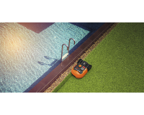 Robotmaaier naast zwembad op gazon