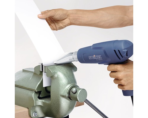 Een heteluchtpistool wordt gebruikt om een werkstuk in een bankschroef te bewerken.