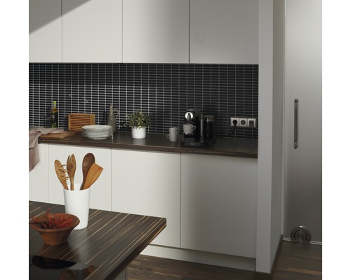 Lichte keuken met donker werkblad, donkere achterwandtegels en houten accenten.