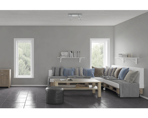 Woonkamer met raam, houten meubels, palletbank, bijzettafel en boekenplank.