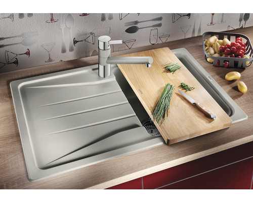 Keuken spoelbak met snijplank, kraan, groenten en aardappelen